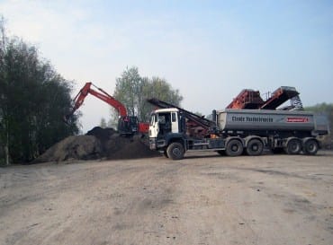 Realisatiefoto van een kraan en machines aan het werk op een grondwerf
